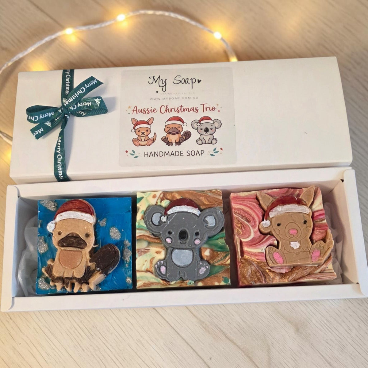 My Soap Aussie Christmas Trio gift set featuring handmade platypus, koala, and kangaroo soaps wearing Santa hats.
