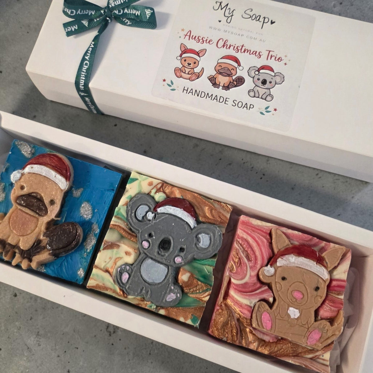 My Soap Aussie Christmas Trio handmade soaps featuring kangaroo, platypus, and koala designs with festive Santa hats.