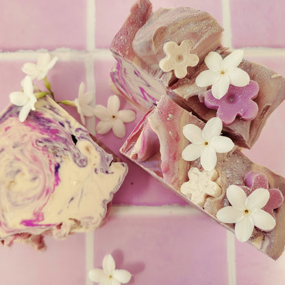 My Soap Sweet Pea & Jasmine artisanal soap with swirls of purple and pink, topped with white jasmine flowers and glitter.