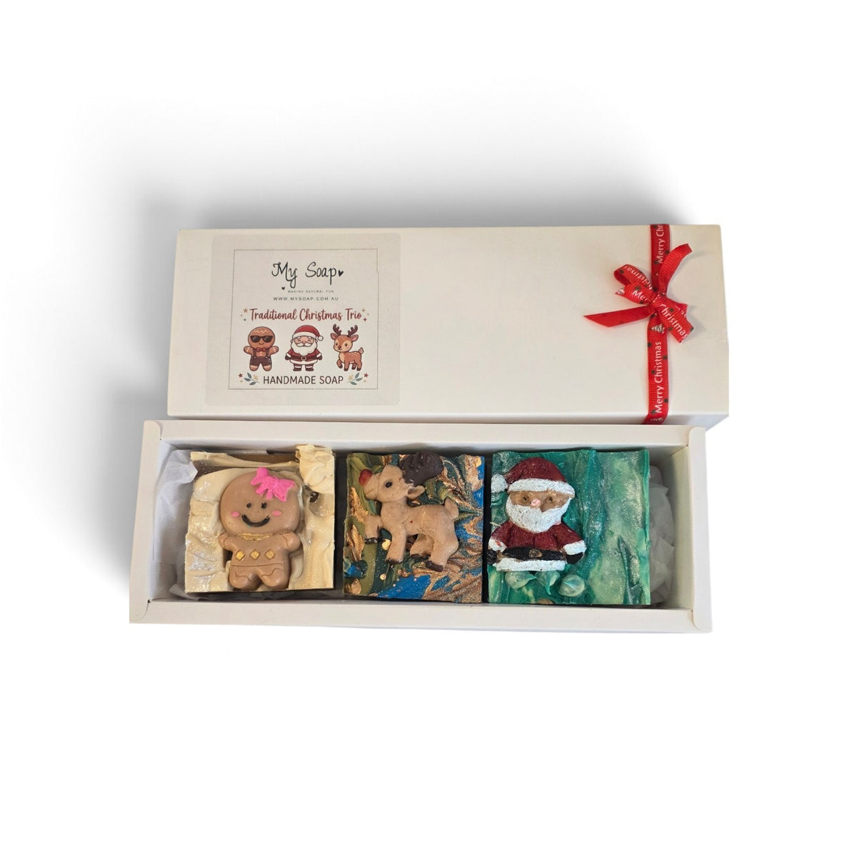 My Soap Traditional Christmas Trio gift set featuring handmade gingerbread, reindeer, and Santa soaps in a ribbon box.